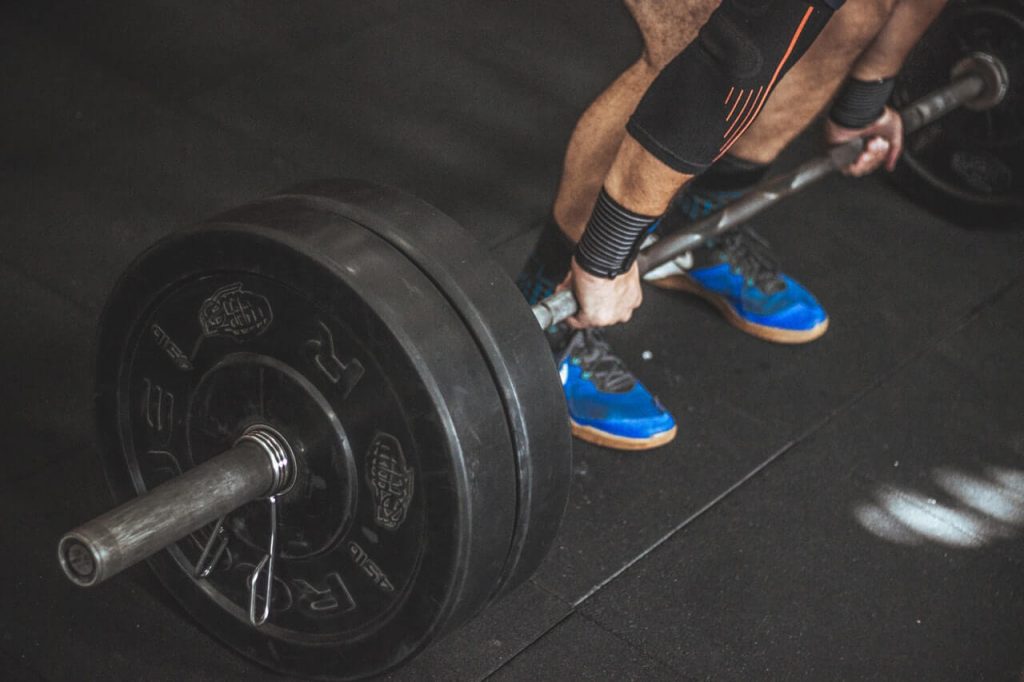 Crossfitter holding barbell with plates