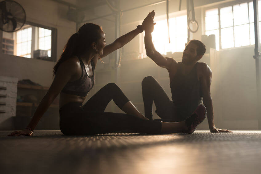 Crossfitters after successful exercising session in gym