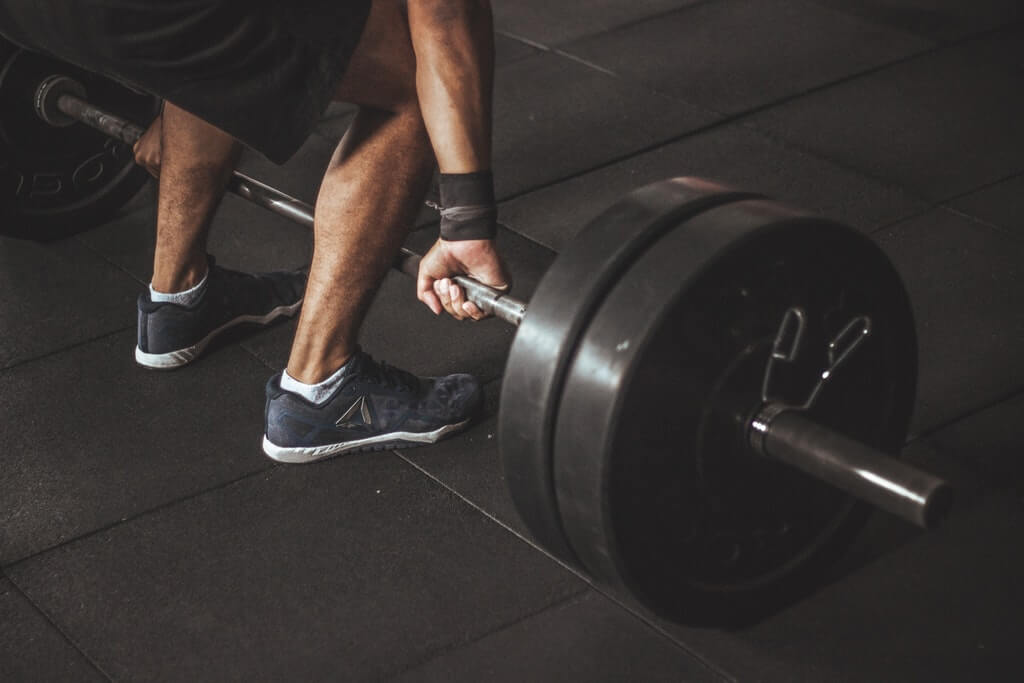 man lifting barbell in CrossFit gym