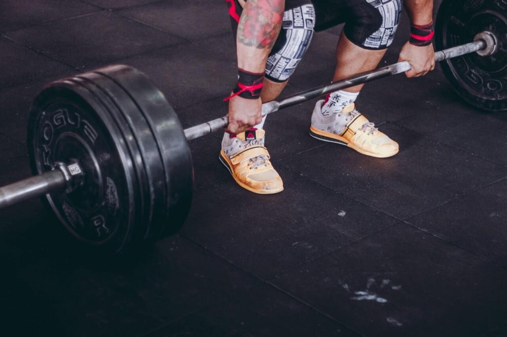 man lifting barbell in gym