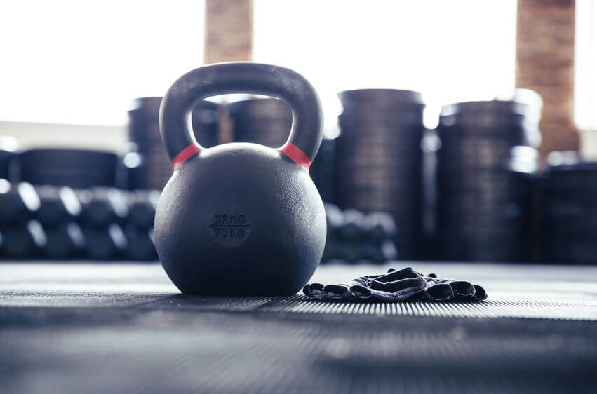 closeup image of a kettlebell and CrossFit gloves in gym