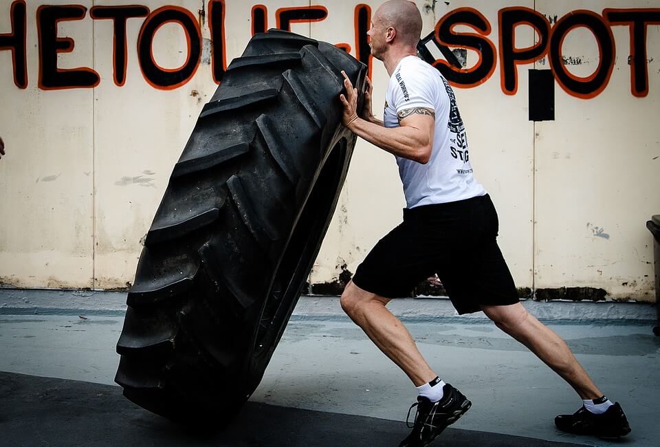 man lifting tire