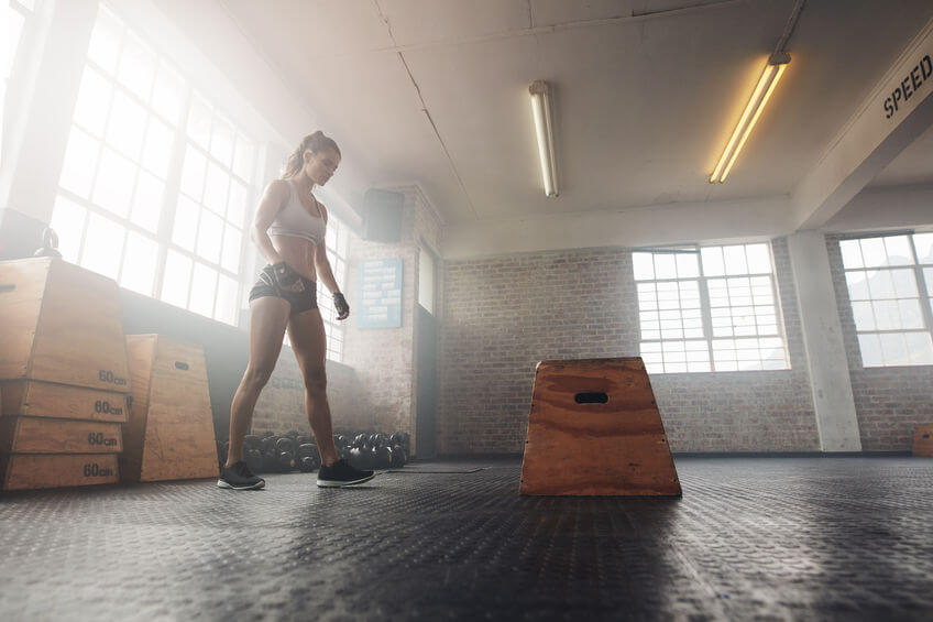 woman doing plyo jump box workout at the gym