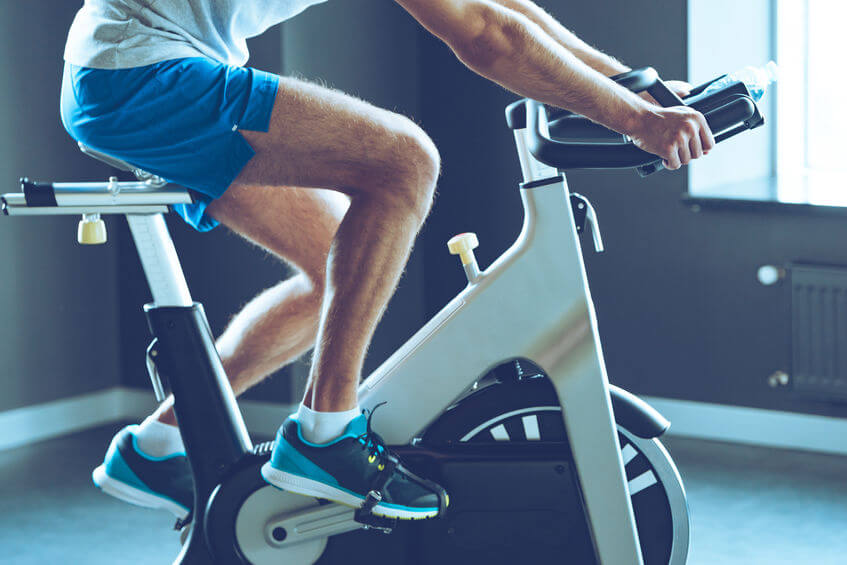 man in sportswear cycling at gym