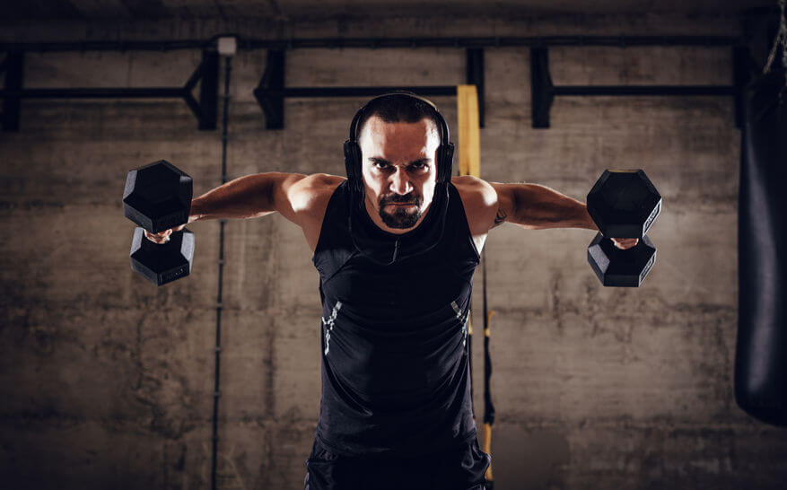 man with headphones doing exercise in CrossFit gym