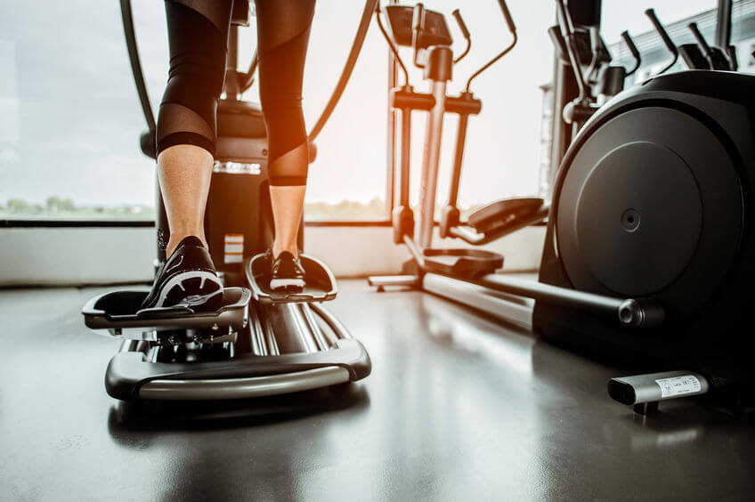 woman working out on an elliptical trainer in gym