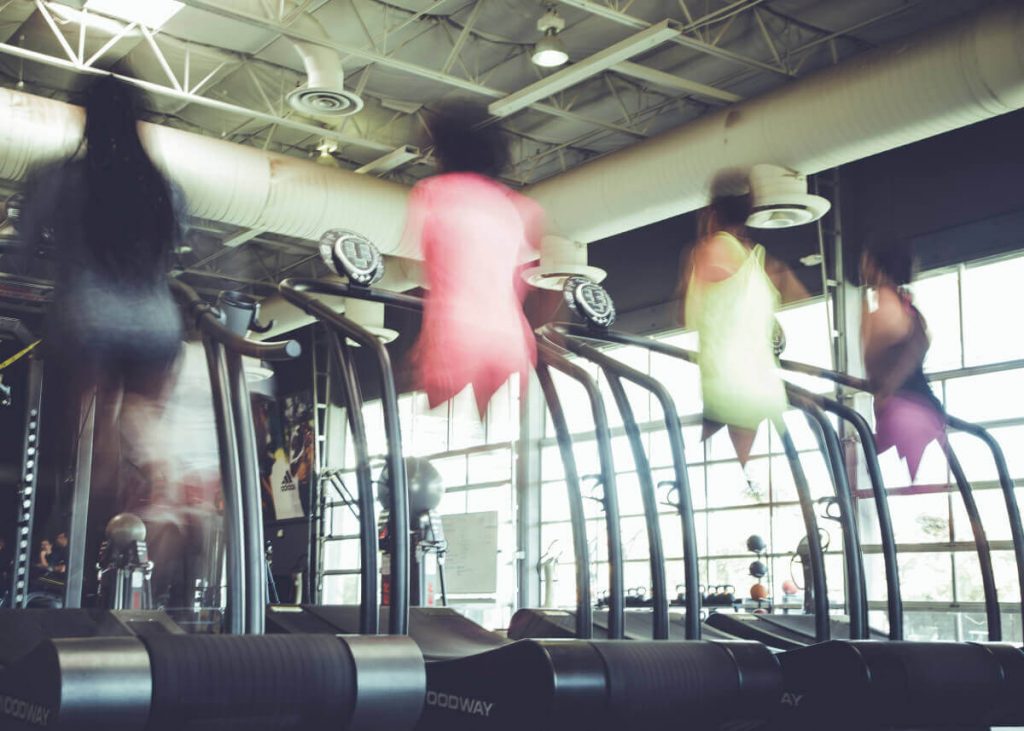 people running on manual treadmills at the gym