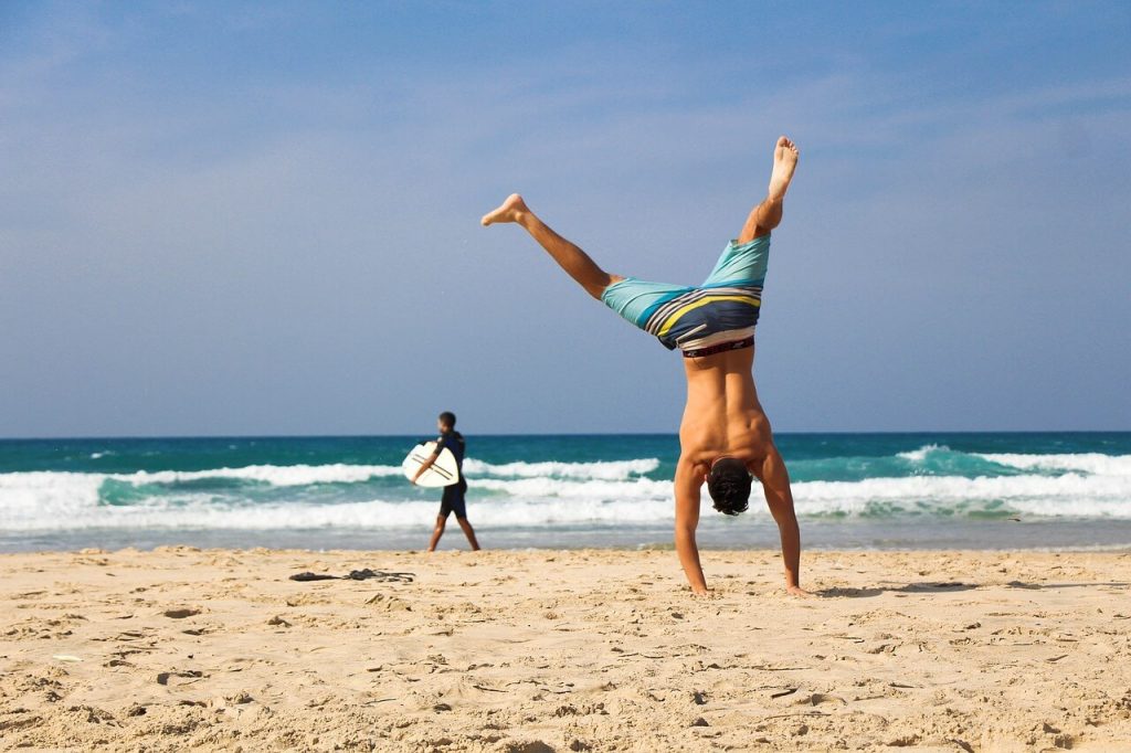 handstand man workout on beach vacation