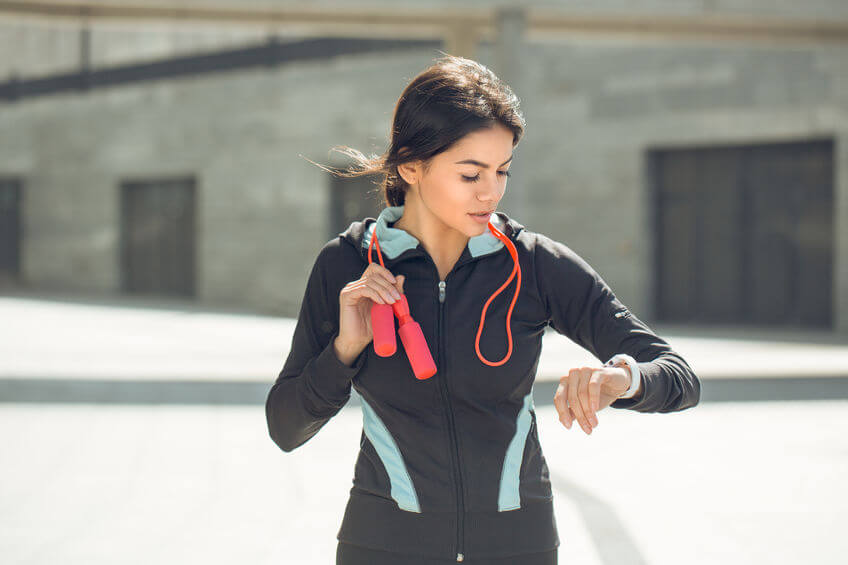 Young active woman wearing fitness watch 