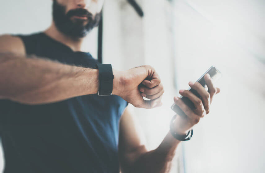 man after workout checks fitness results in activity tracker