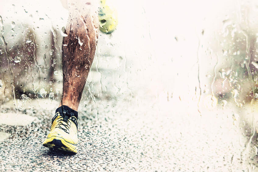 closeup of runners foot touching the asphalt rainy weather