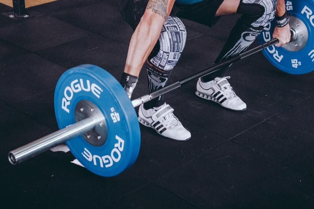 man doing workout with Rogue Fitness olympic barbell