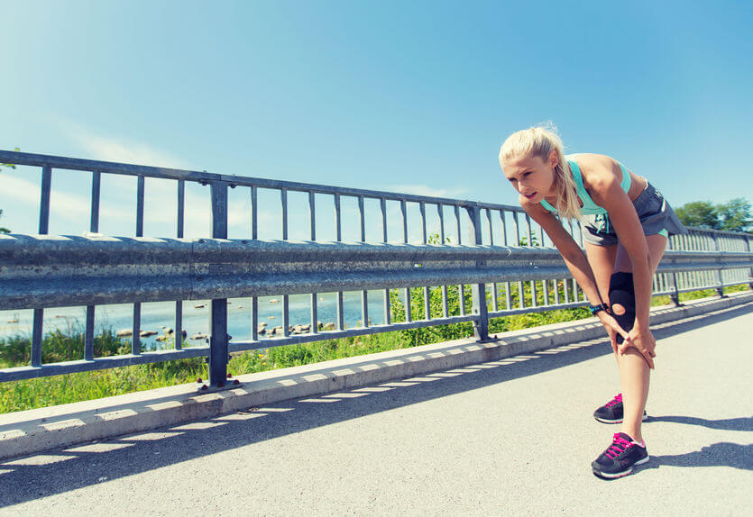  young woman with knee support brace and injured leg