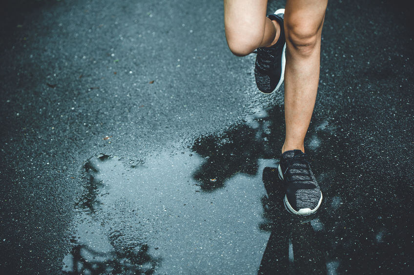 running in the rain on wet asphalt road