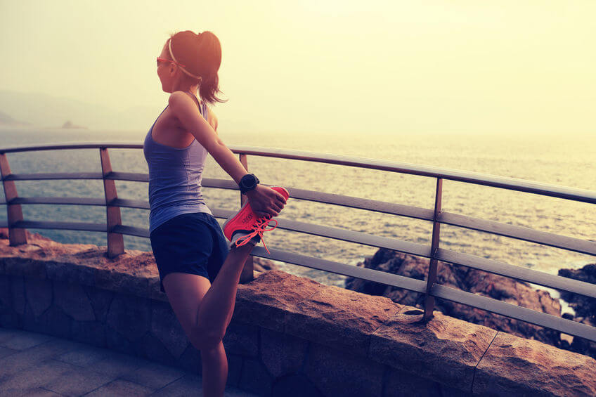 woman stretching legs before running