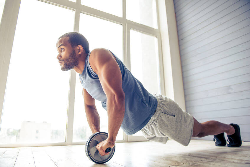 man is doing ab wheel rollout exercise