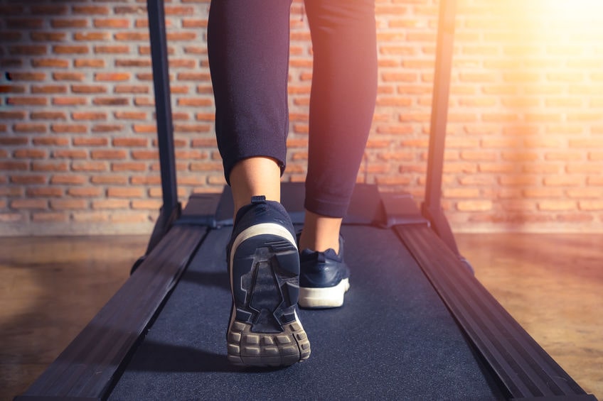 woman running in a gym on folding treadmill