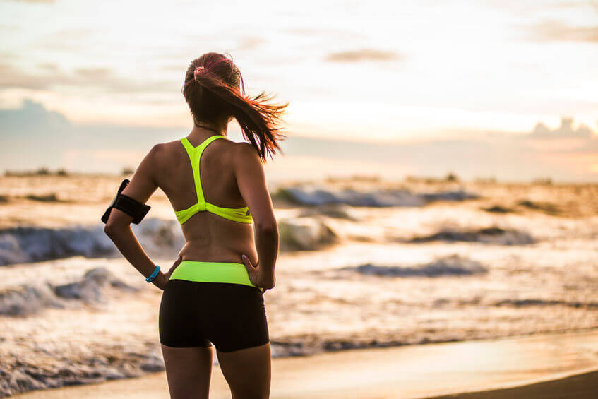 woman running at sunrise beach