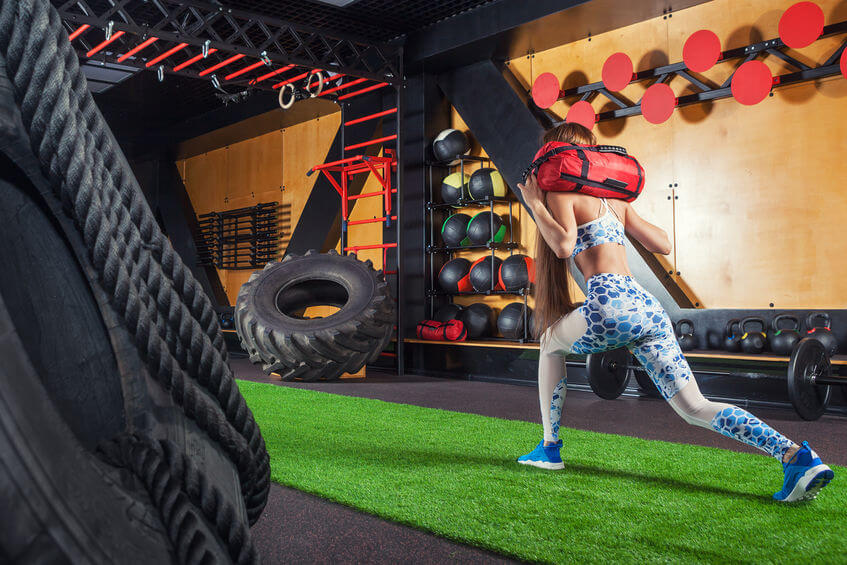 woman doing sit-ups with a sandbag