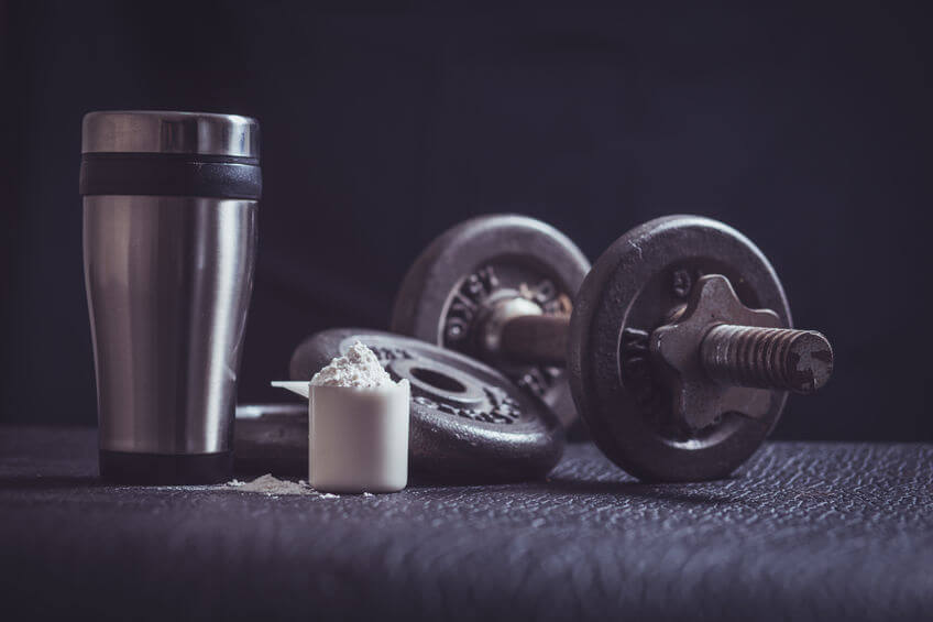 Whey protein shaker and dumbbells