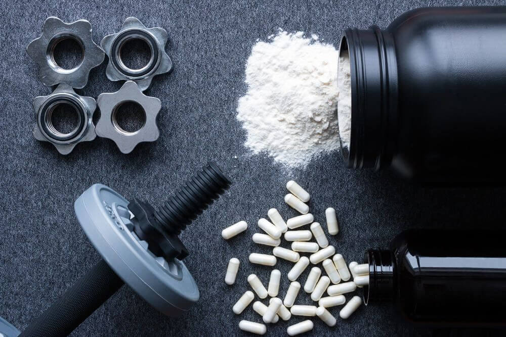 dumbbells, protein powder and amino acids