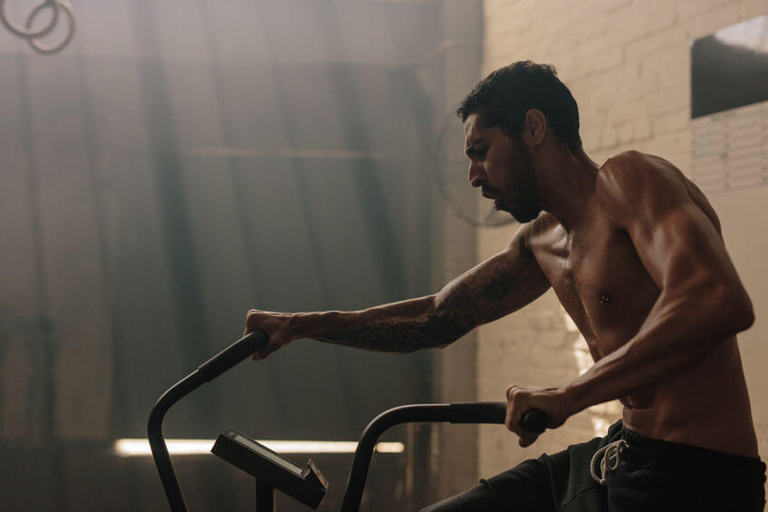 man using air bike for cardio workout at gym