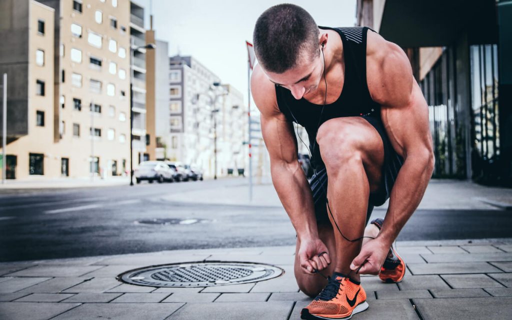 man tying his running shoes