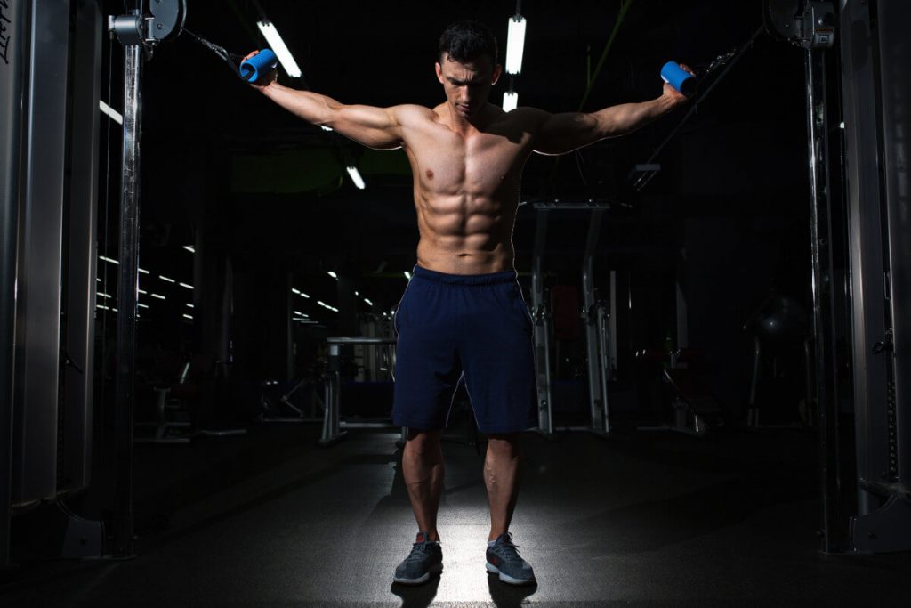 man using cable crossover machine in gym