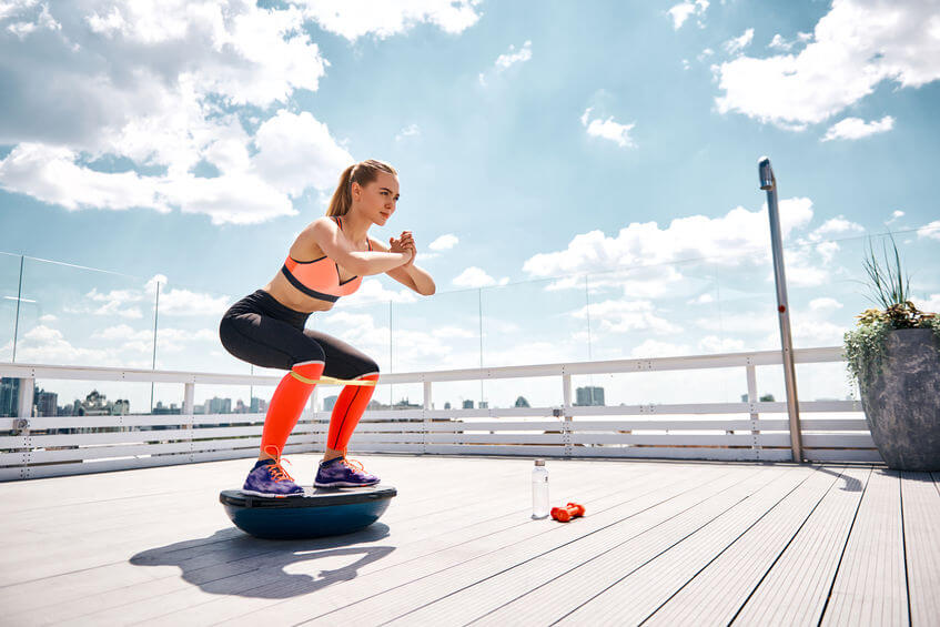 athlete girl work out with Bosu ball trainer