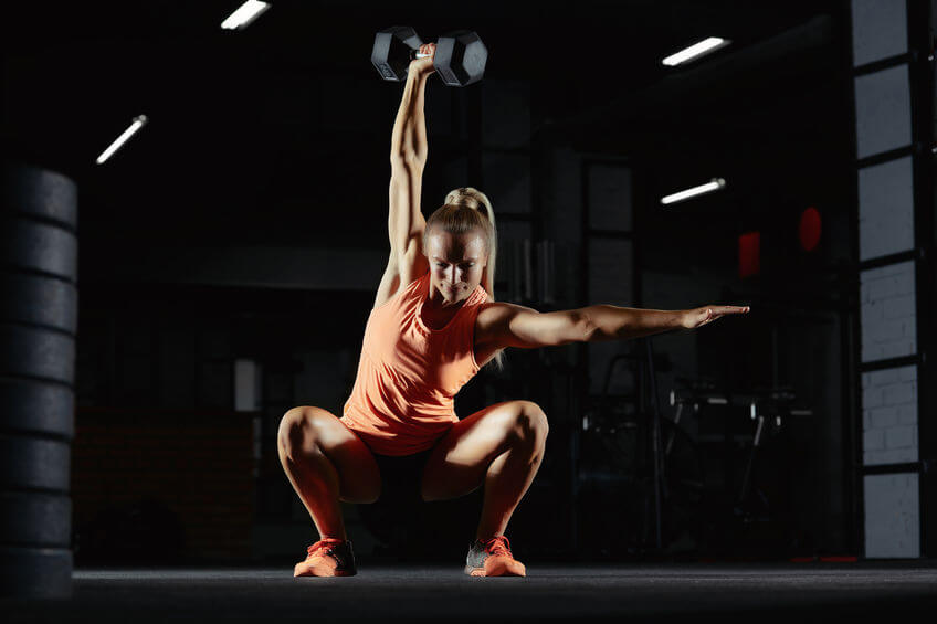 female crossfit athlete exercising with dumbbell