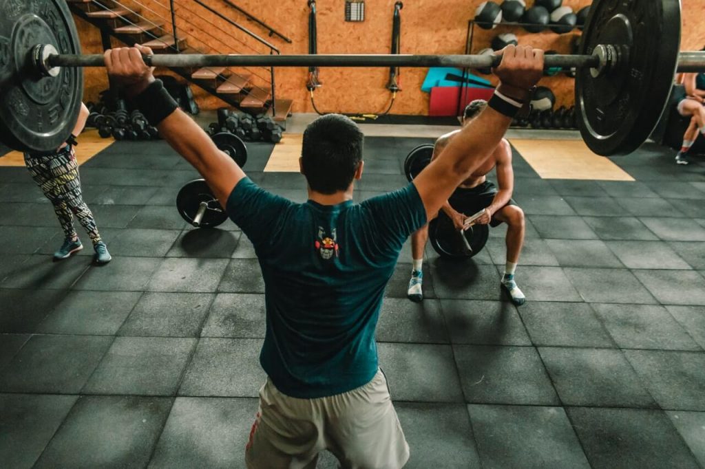 person lifting barbell at indoor gym