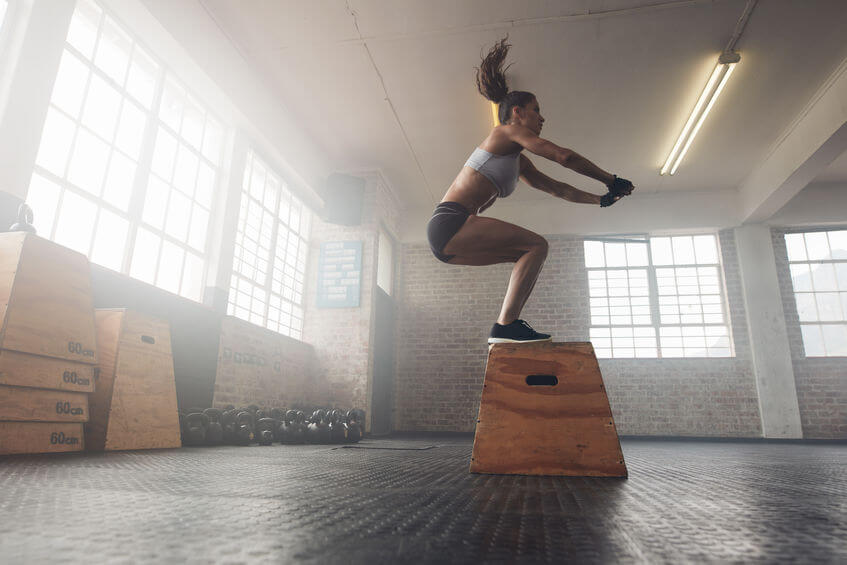 woman doing a box jump exercise at the CrossFit gym