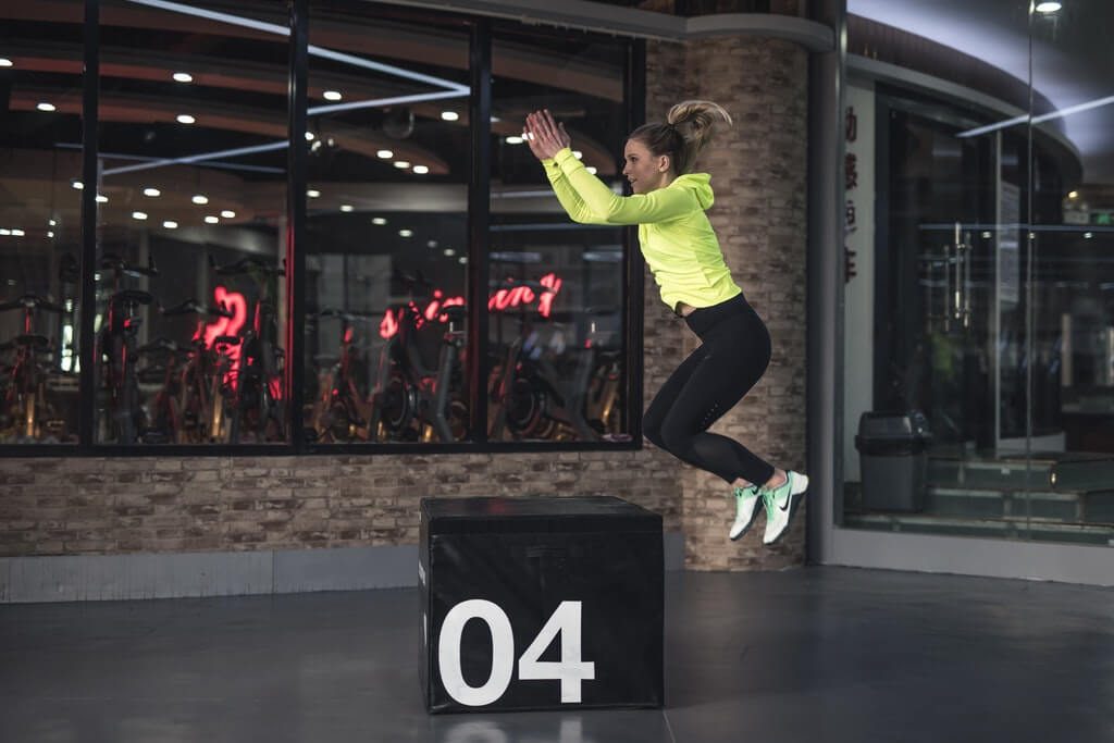 woman jumping on box at gym