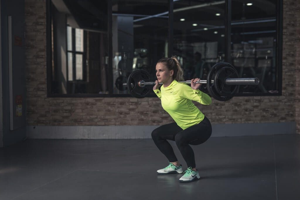 woman lifting barbell at CrossFit gym