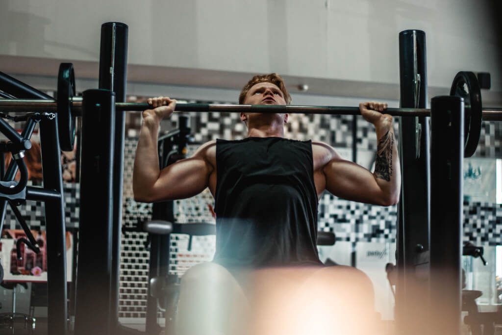 man lifting barbell during workout