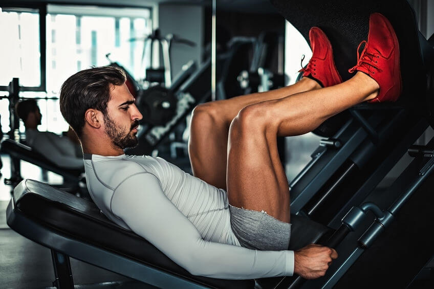 man training legs on the leg press machine in the gym