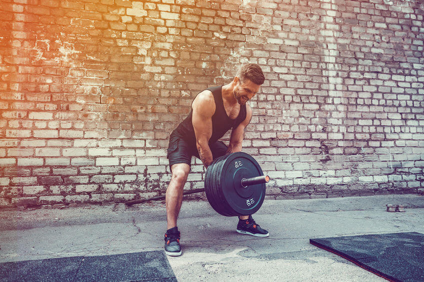 man working out with a barbell t bar exercise