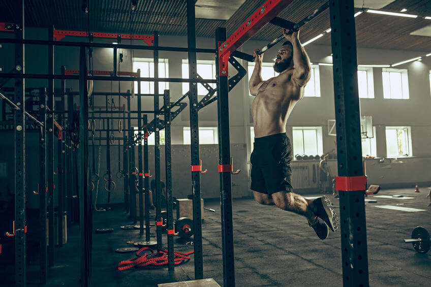 muscular man doing pull ups at CrossFit gym