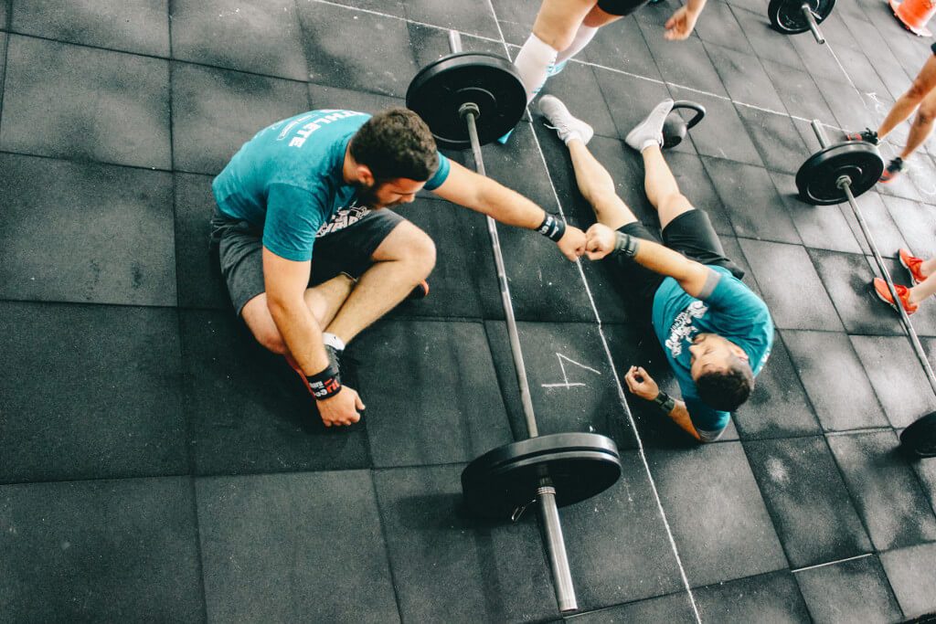 two men in crossfit gym after hard workout