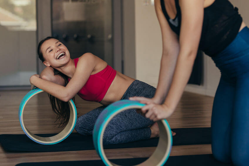 women doing pilates training at a gym using yoga wheel