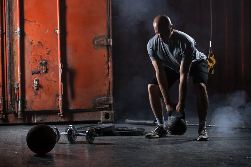 athlete doing squats with kettlebell