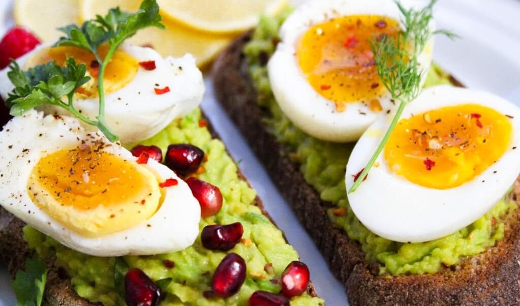 sliced eggs on top of green salad with bread