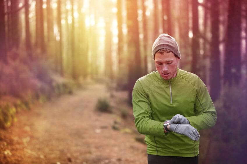 trail runner looking at heart rate monitor watch