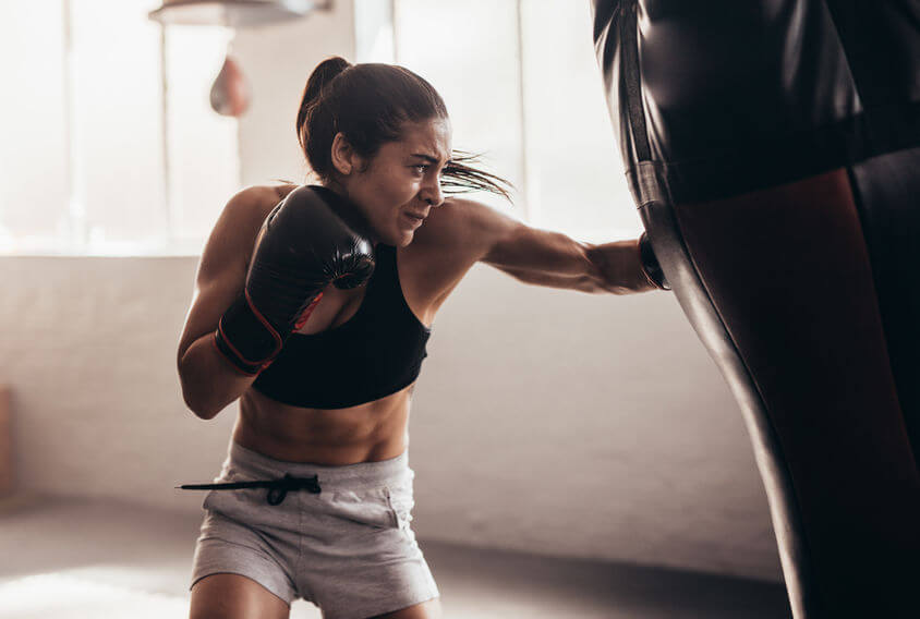 female boxer hitting punching bag