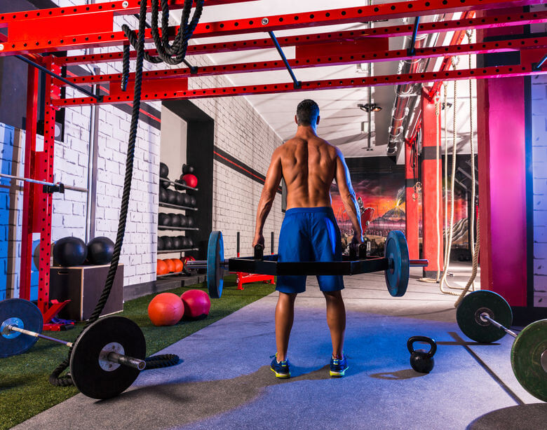 man at gym doing workout with hex trap bar