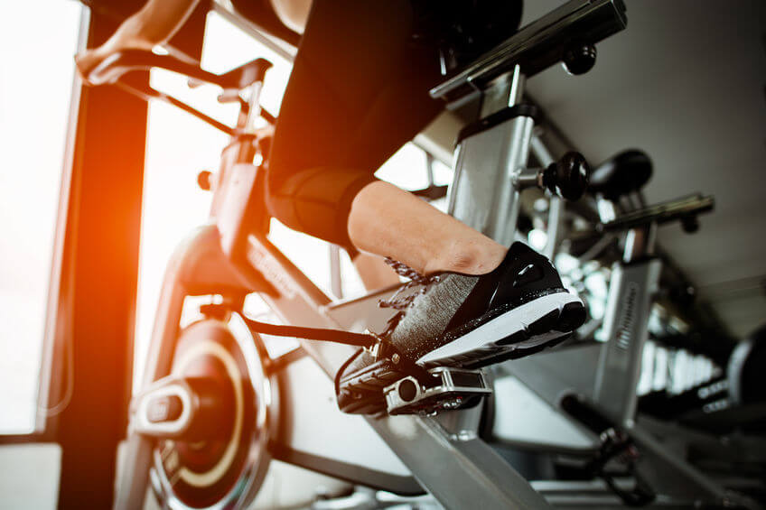 woman working out on upright exercise bike at the gym