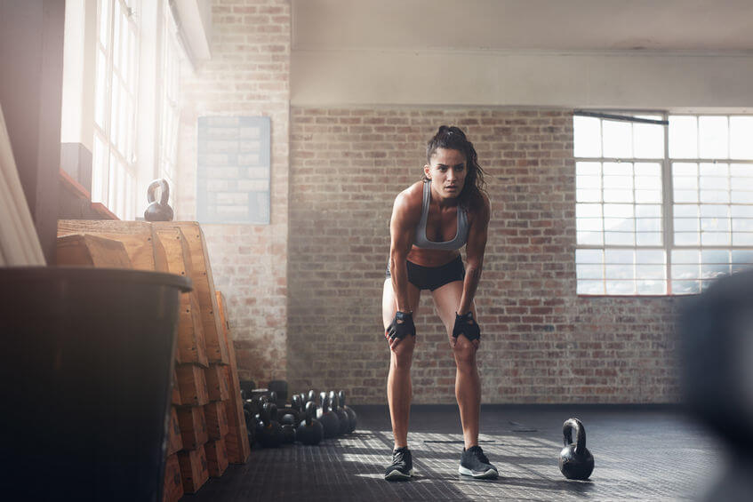 woman at CrossFit gym wearing weight lifting gloves