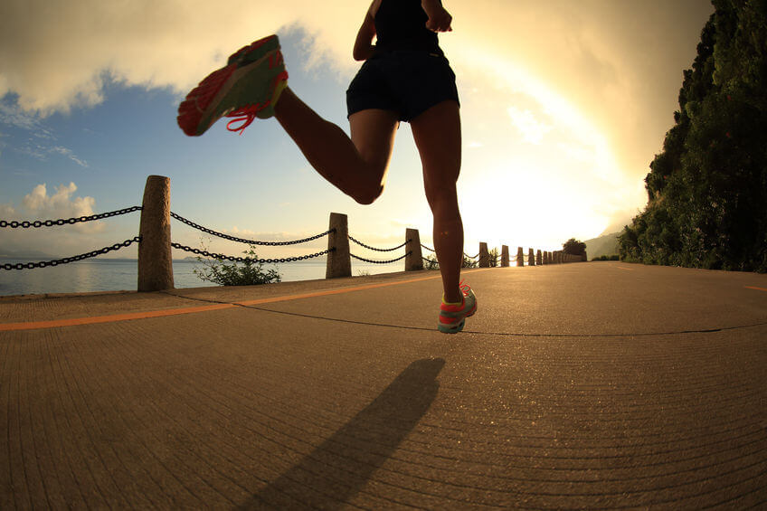 woman running on sunrise seaside trail